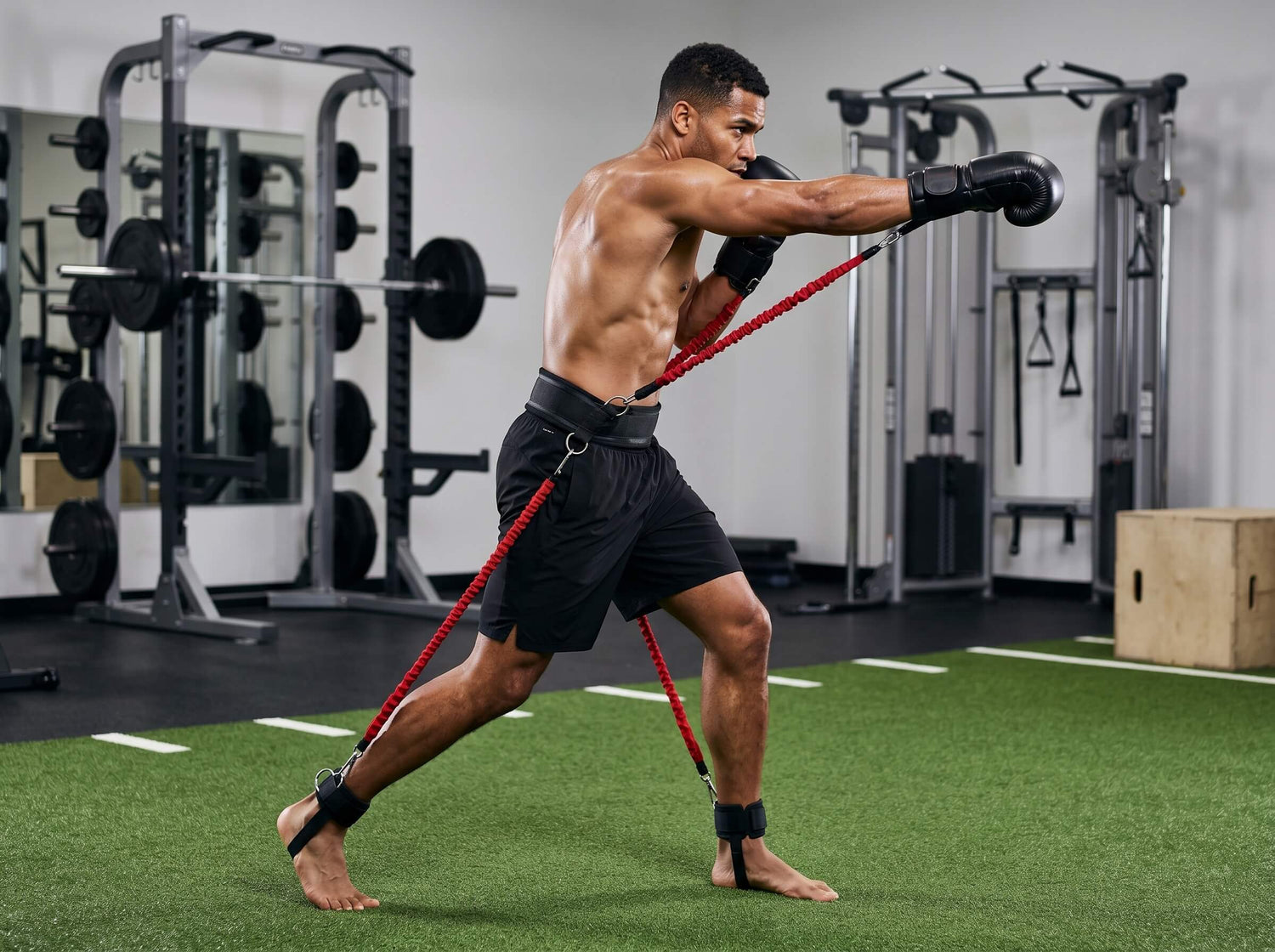 A boxer working out in the gym with a set of red resistance bands
