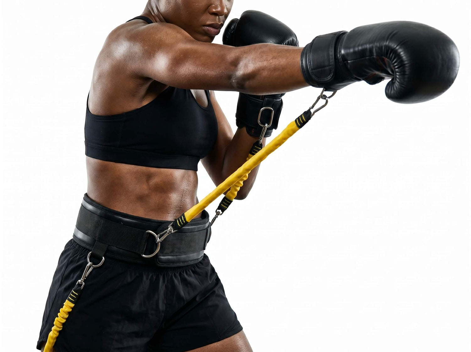 Person wearing black boxing gloves and shorts with a resistance band, on a white background
