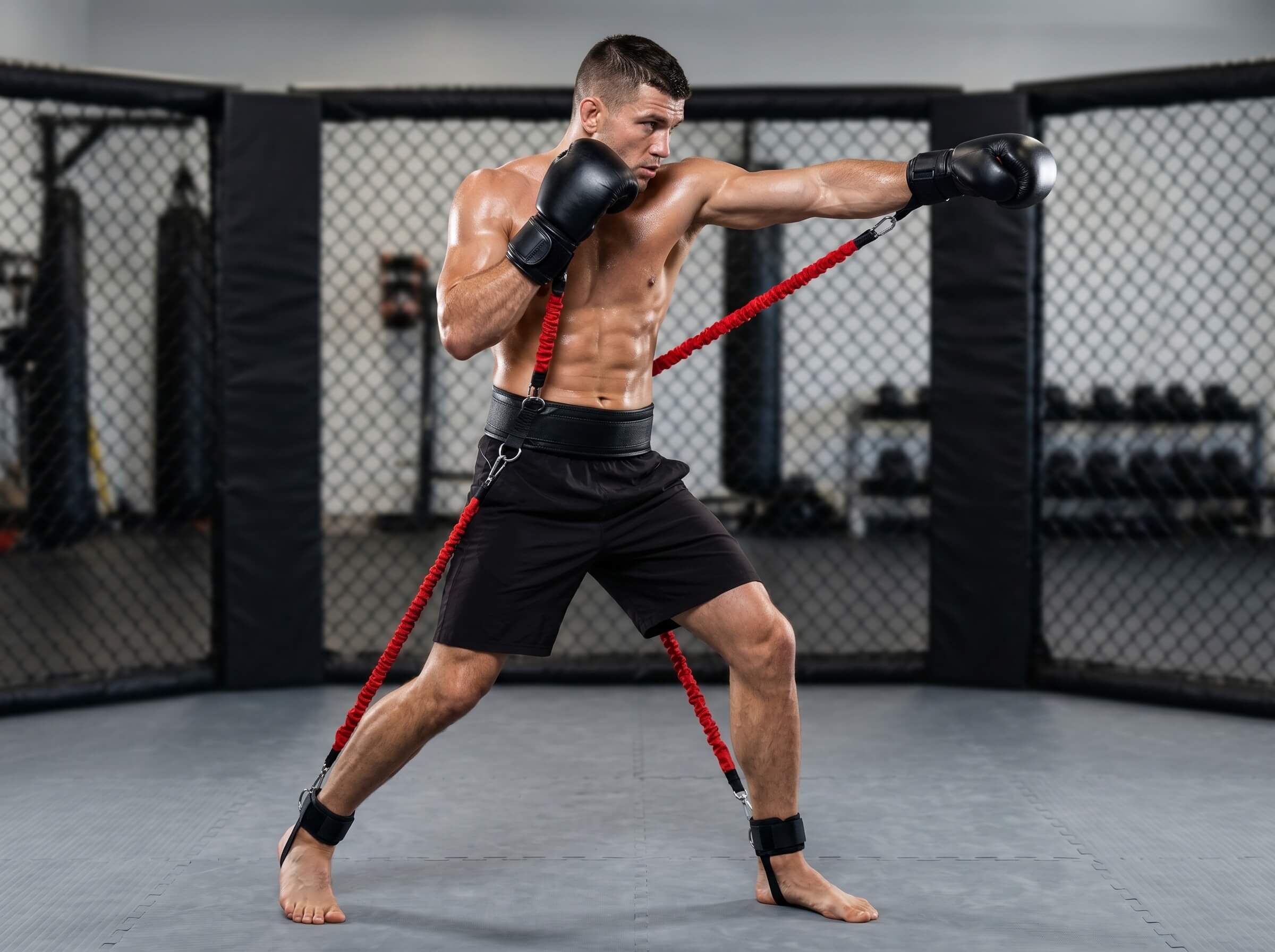 Boxer training with a red resistance band set in a gym setting
