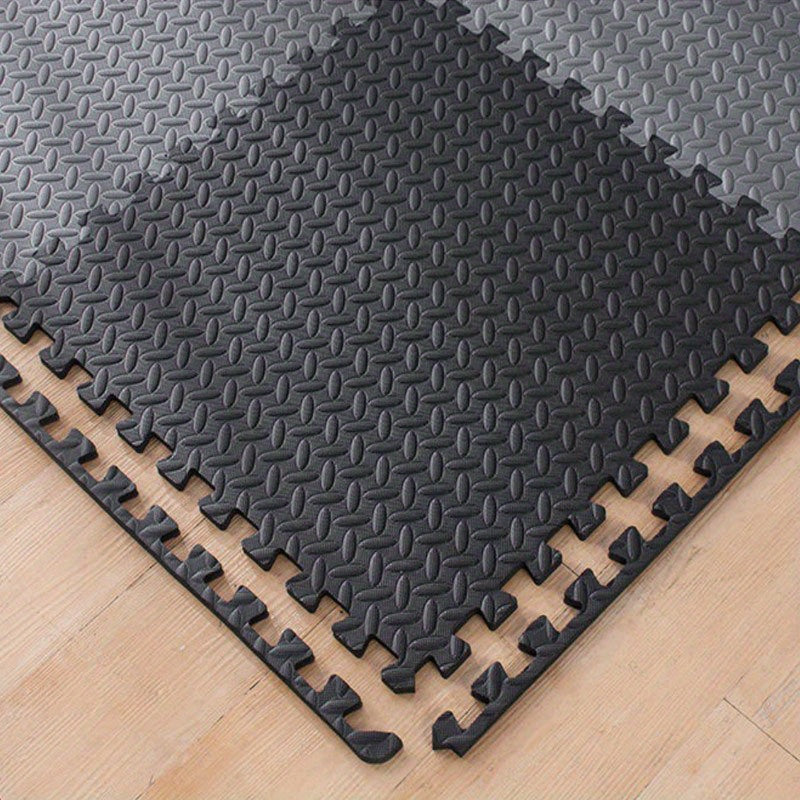 Black interlocking foam mats on a wooden floor