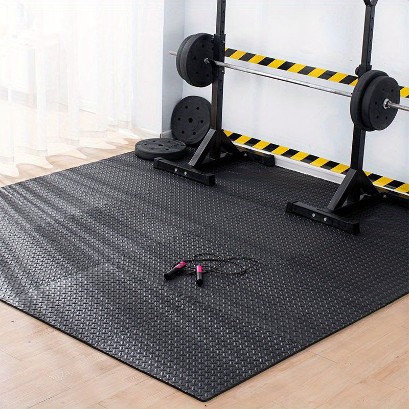 Gym setup with weightlifting equipment on a black mat