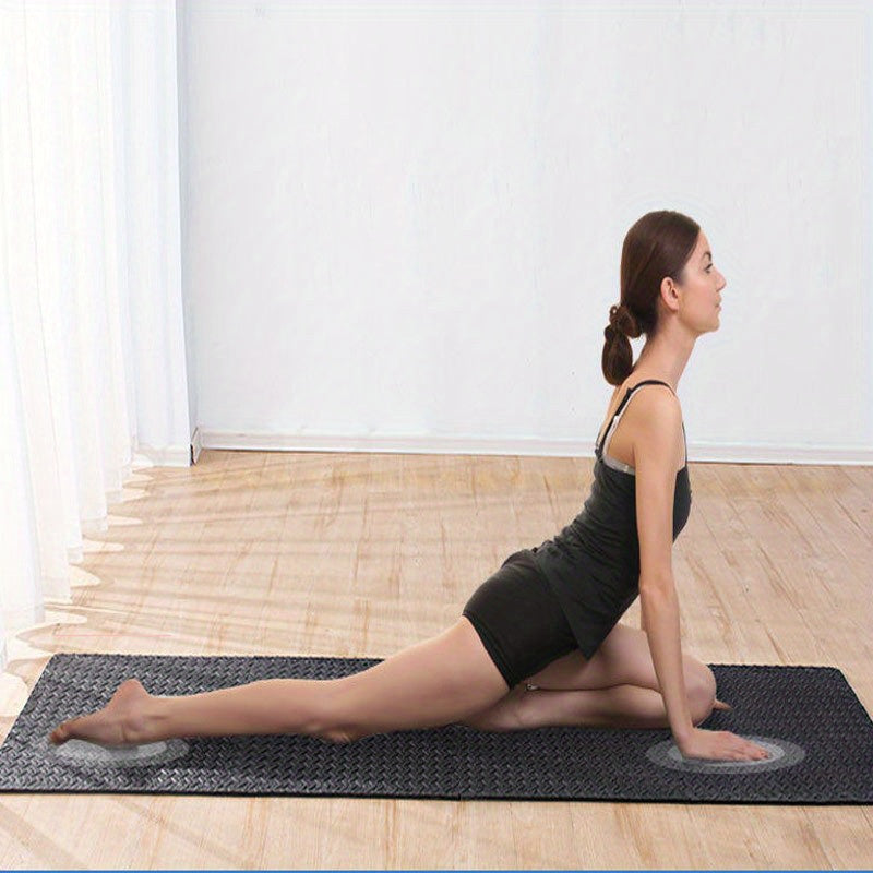 Woman performing a yoga pose on a mat in a room with wooden floor and white walls.