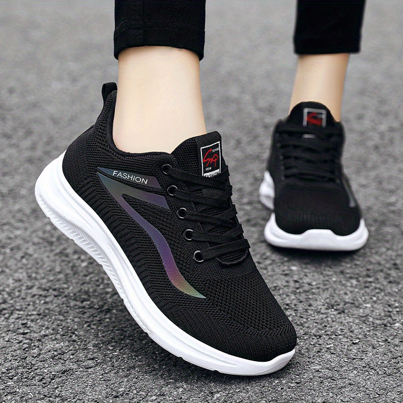 Black athletic shoes with white soles on a gray pavement background