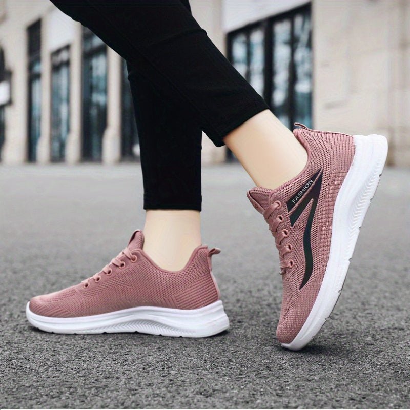 Pink running shoes with white soles on a blurred street background