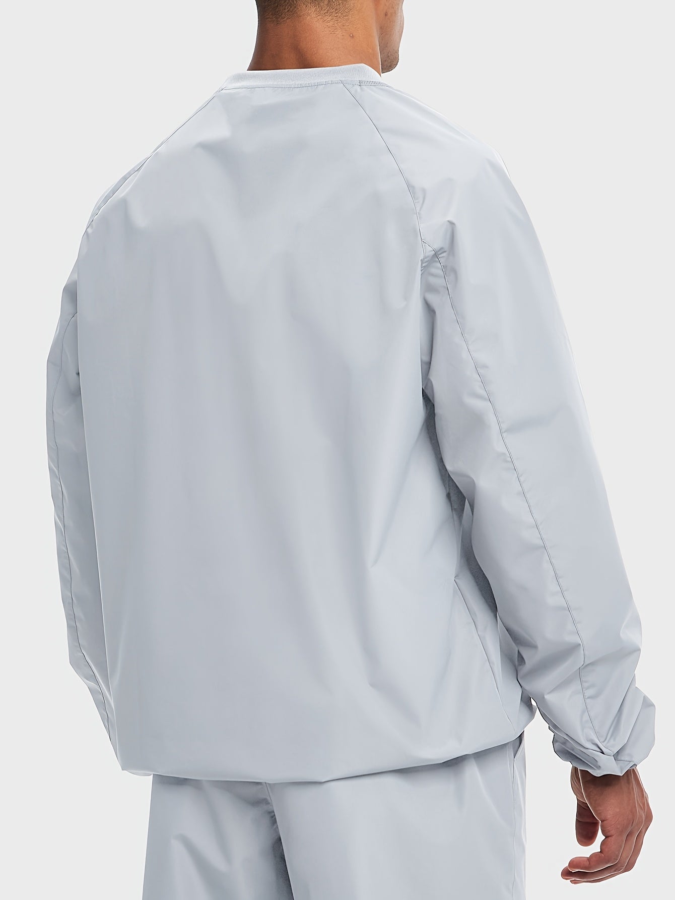 Person wearing a light gray sauna sweat suit top jacket and pants on a white background