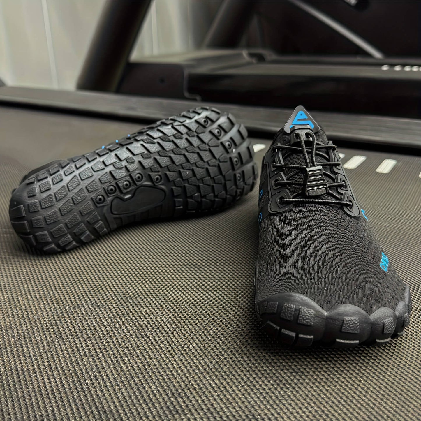 Pair of black and gray deadlift shoes on a textured surface