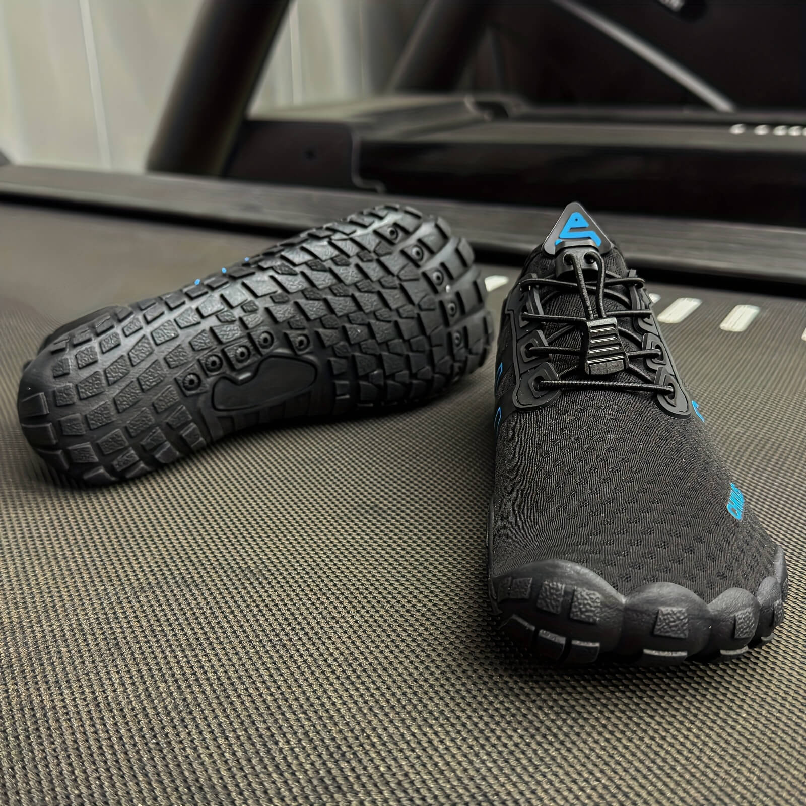 Pair of black and gray deadlift shoes on a textured surface