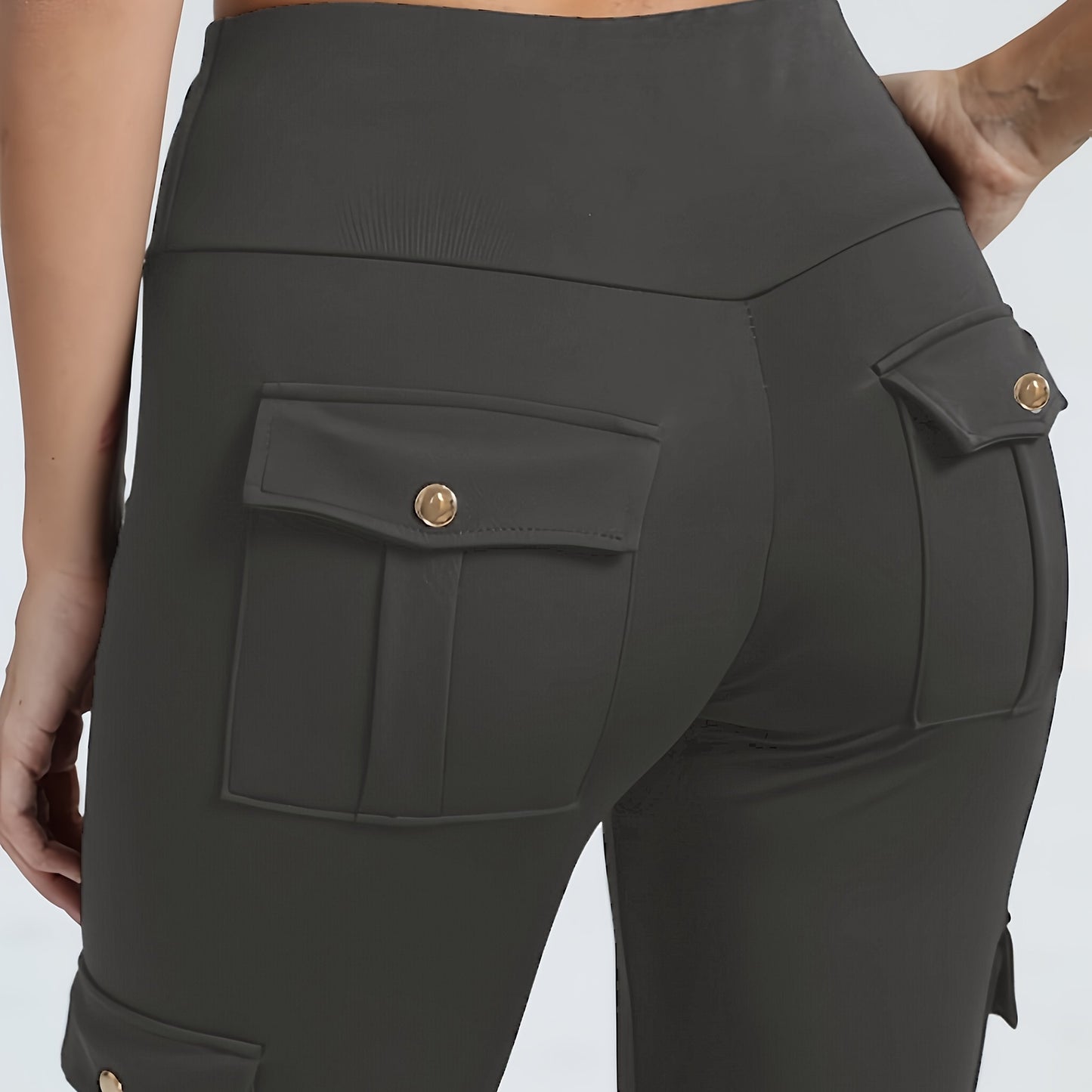 The back view of a woman wearing a pair of grey yoga legging sold by 100 Spartans