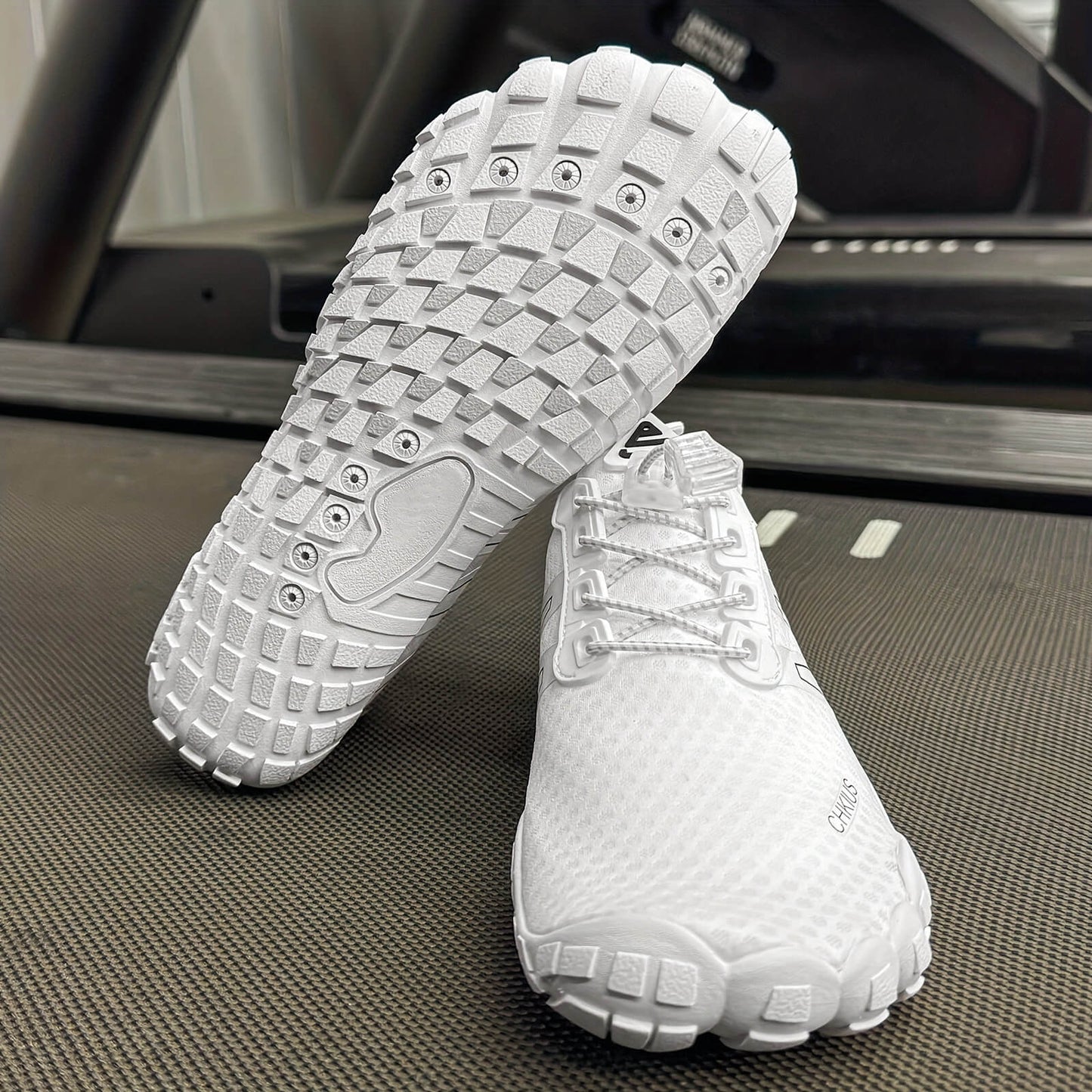 White deadlift shoes with textured soles on a textured surface