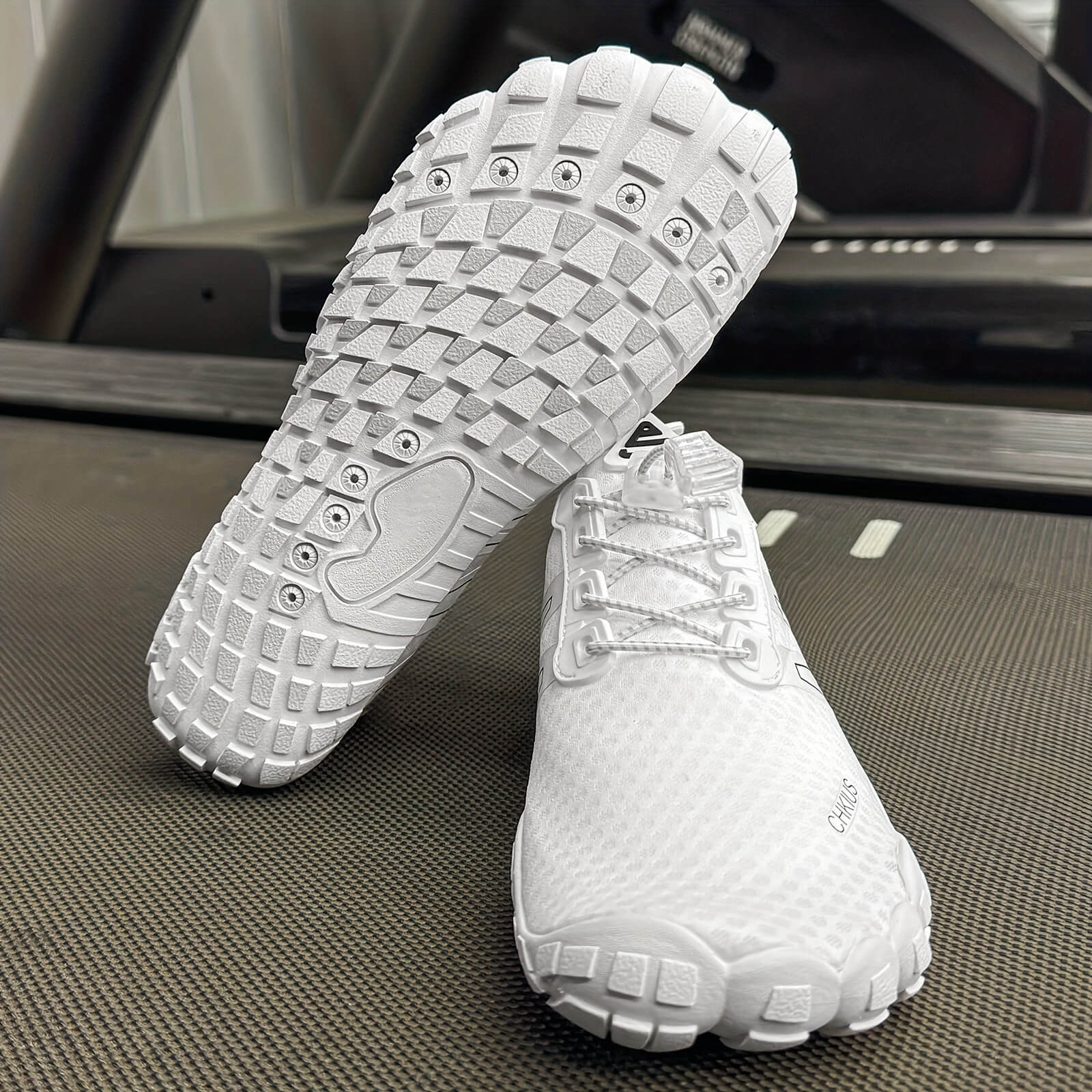 White deadlift shoes with textured soles on a textured surface