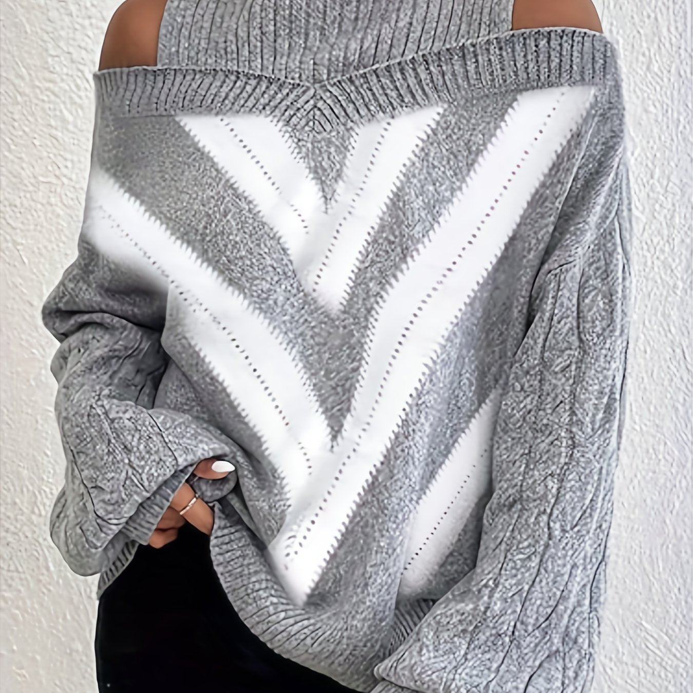 Gray off the shoulder sweater with a white heart design on a white background
