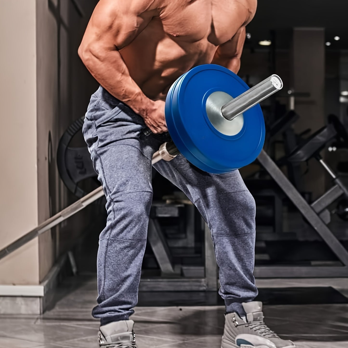 Person lifting a barbell with blue weights with a T Bar Row Attachment in a gym setting