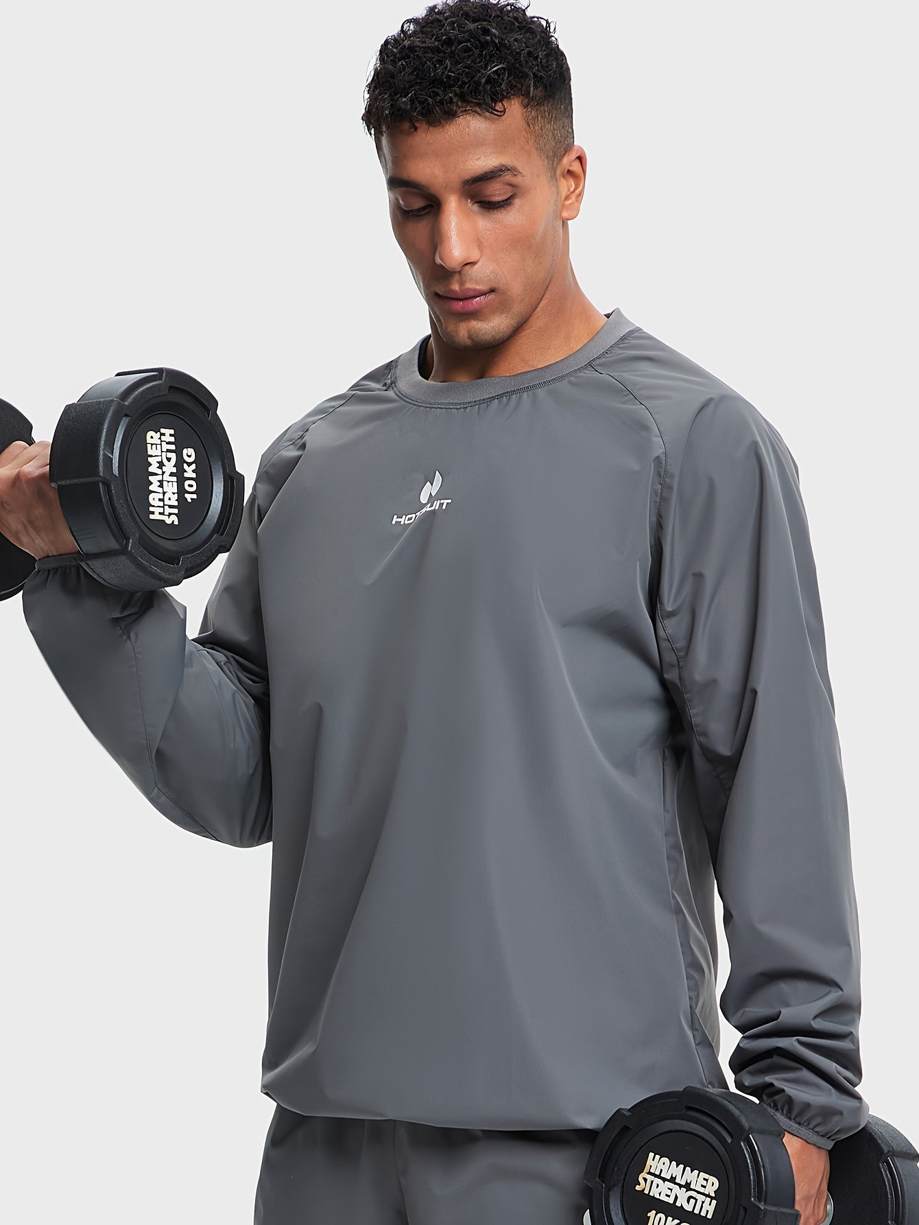 Man lifting weights wearing a gray sauna sweat suit top with a visible brand logo.