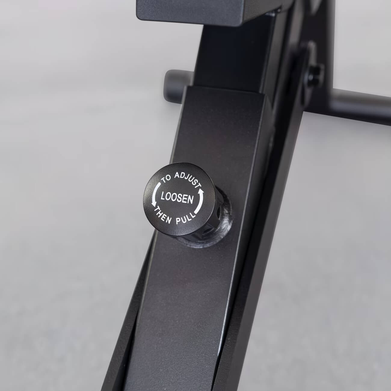 Close-up of a black adjustable stand with a label on a gray background