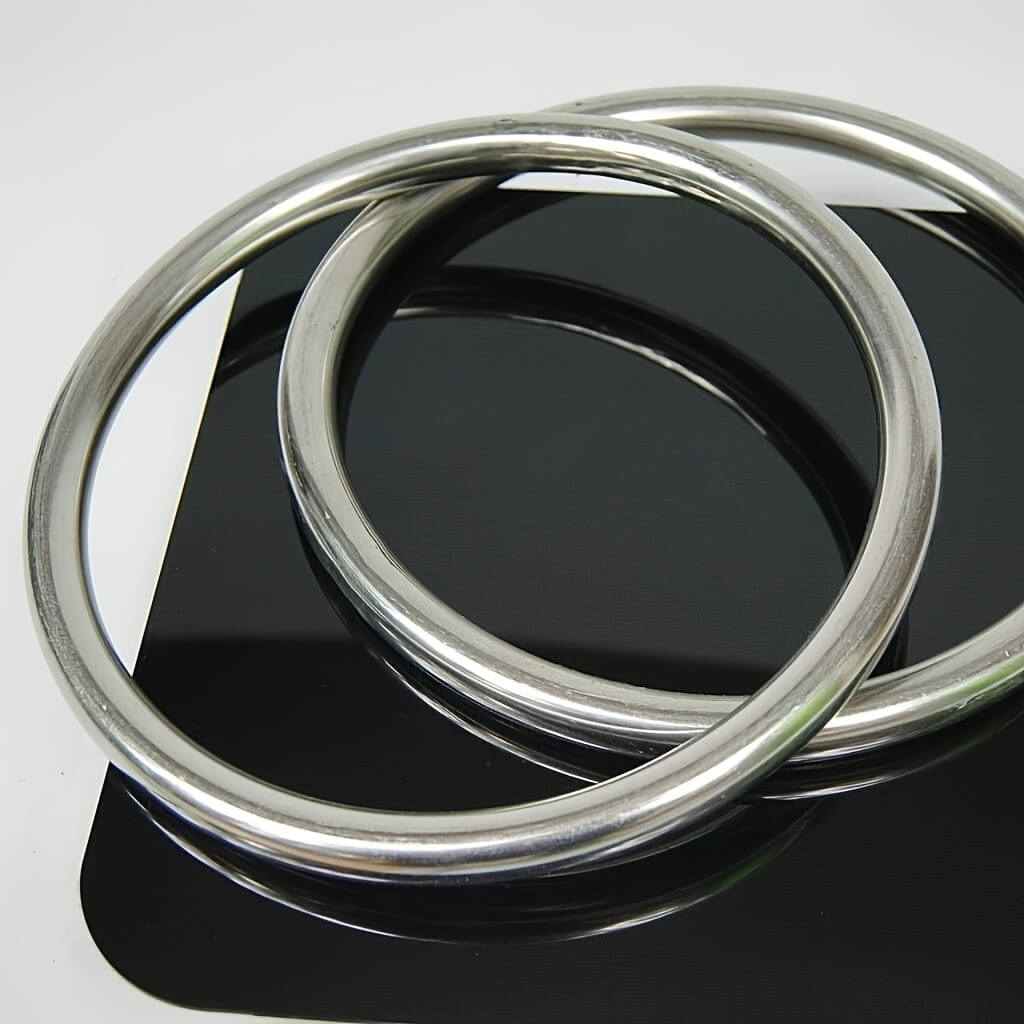 Two wing chun rings on a reflective black surface with a white background