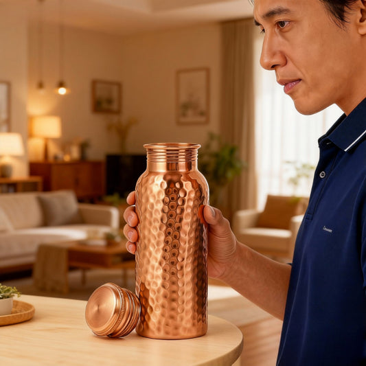 Man holding a copper water bottle in a living room setting