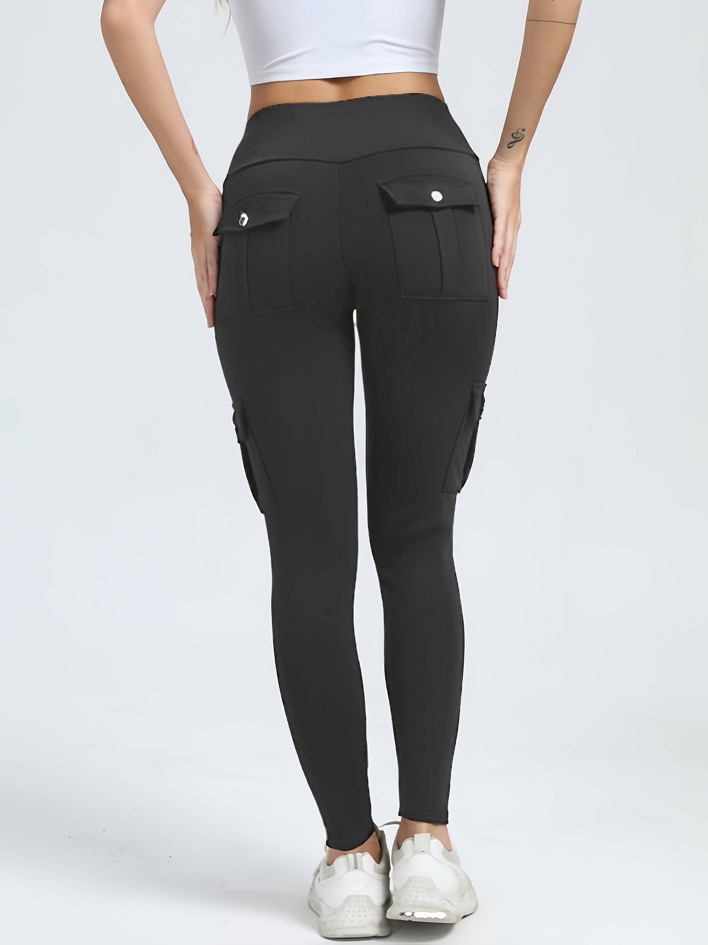 The back view of a woman wearing a pair of grey yoga legging sold by 100 Spartans