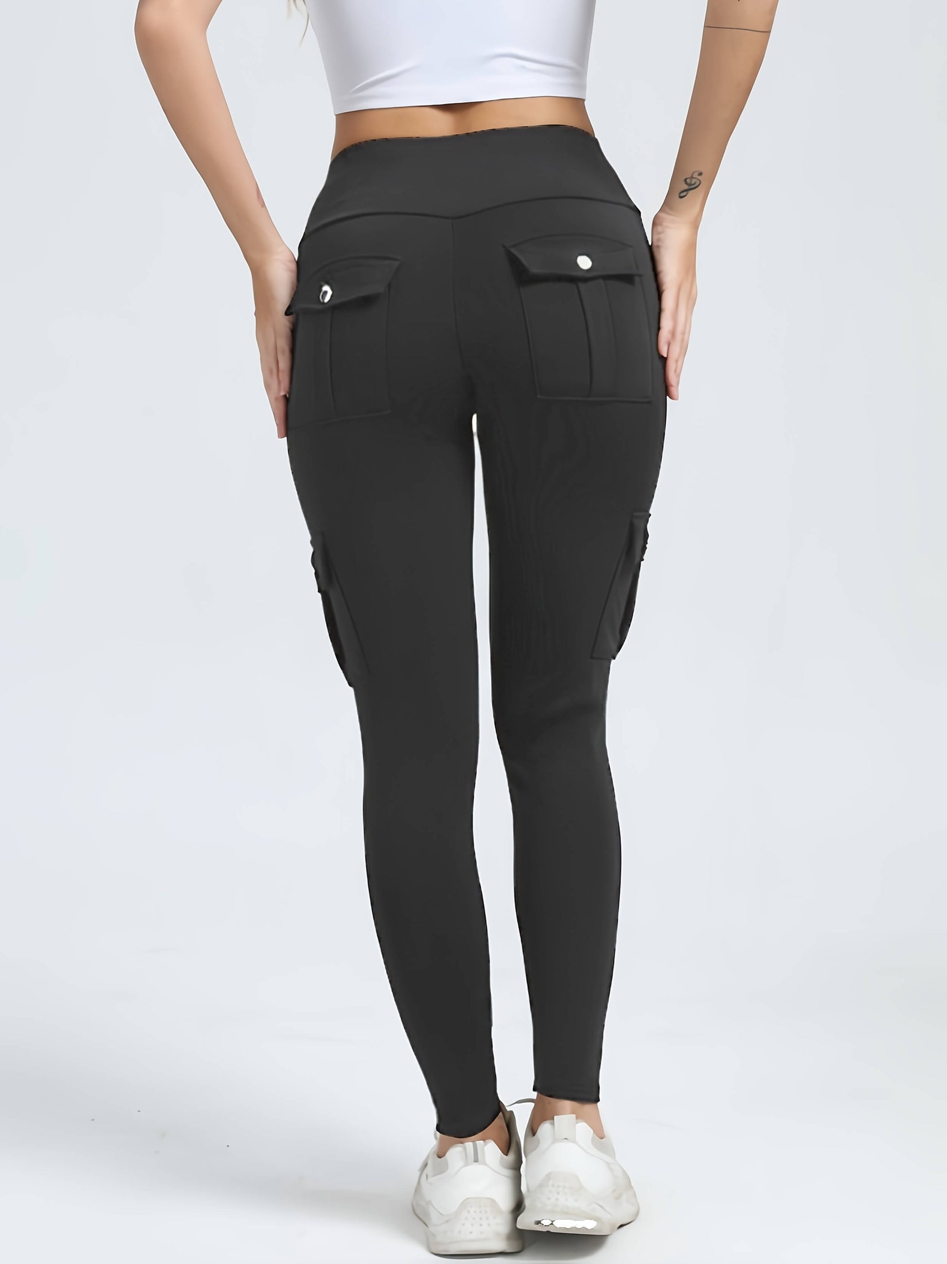 The back view of a woman wearing a pair of grey yoga legging sold by 100 Spartans