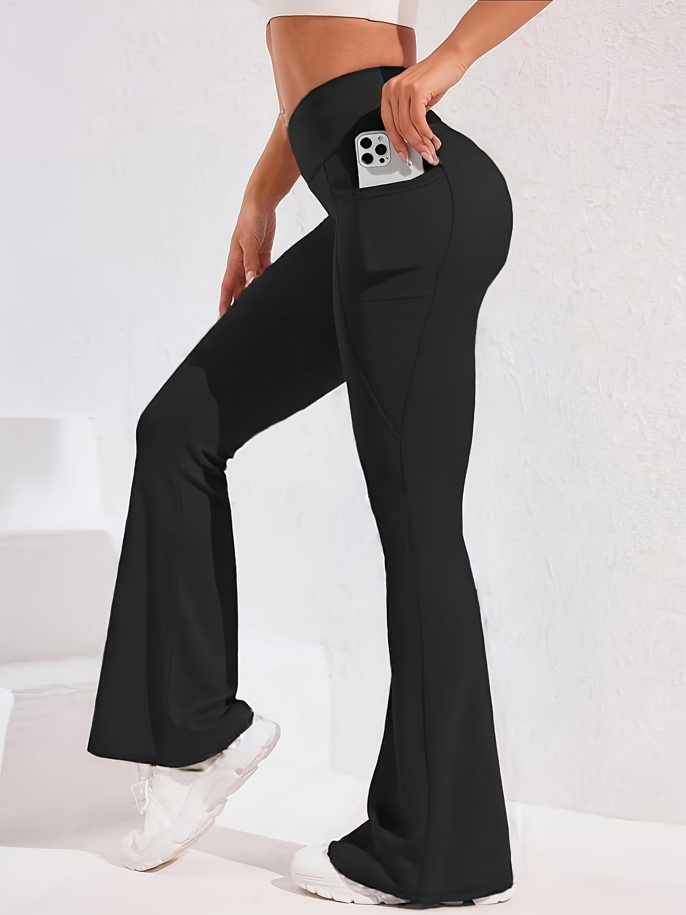 A woman wearing a black women’s flare leggings sold by 100 Spartans