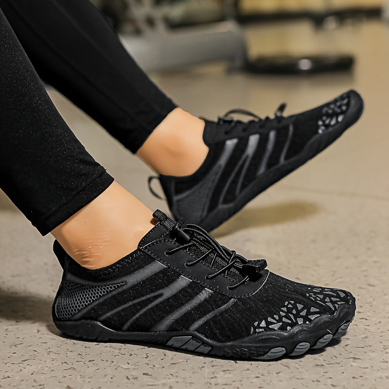 Black deadlift shoes worn by a person on a concrete floor.