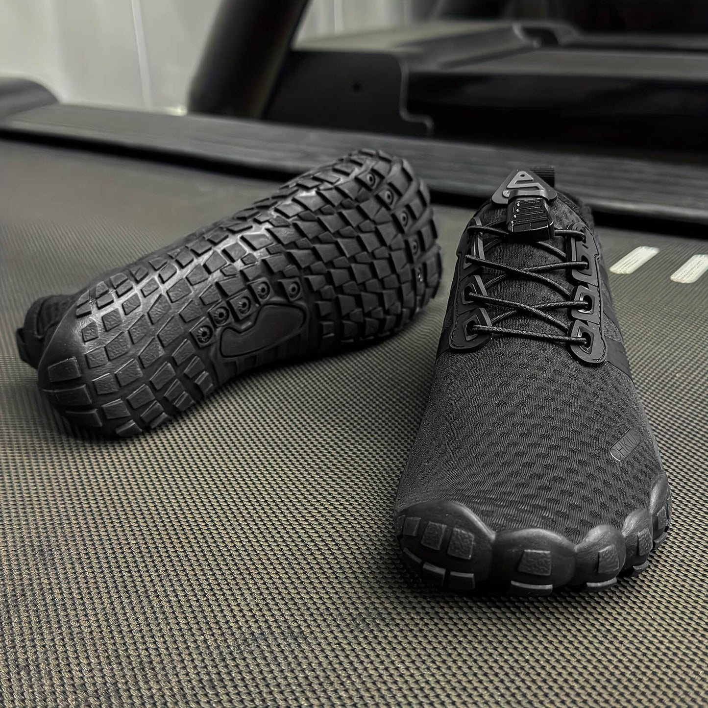 Black deadlift shoes on a textured surface