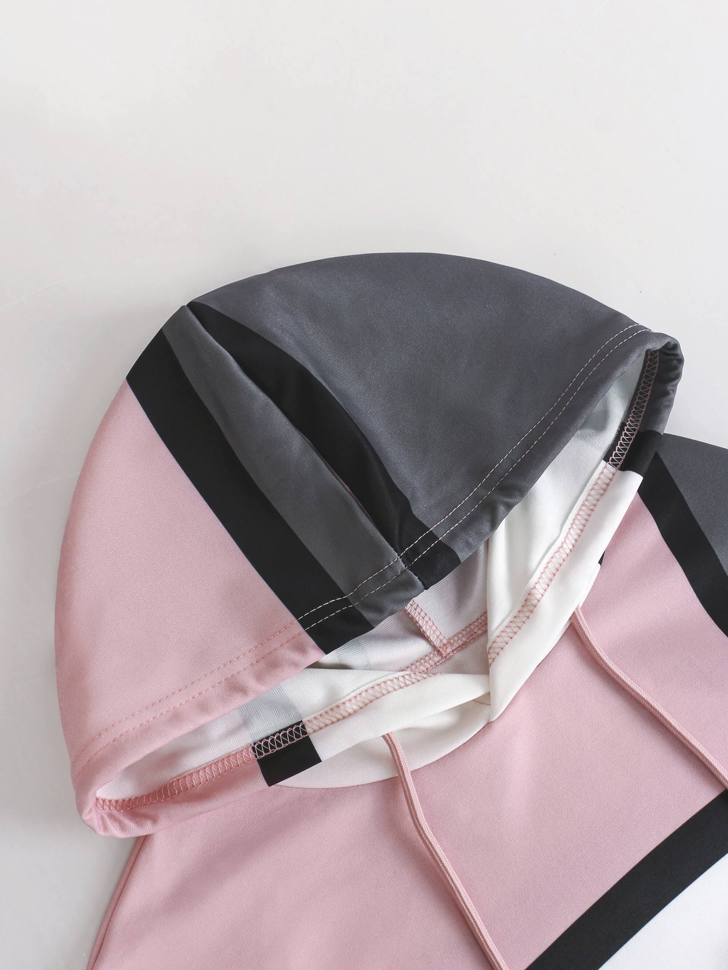 Pink and gray hooded garment on a light background