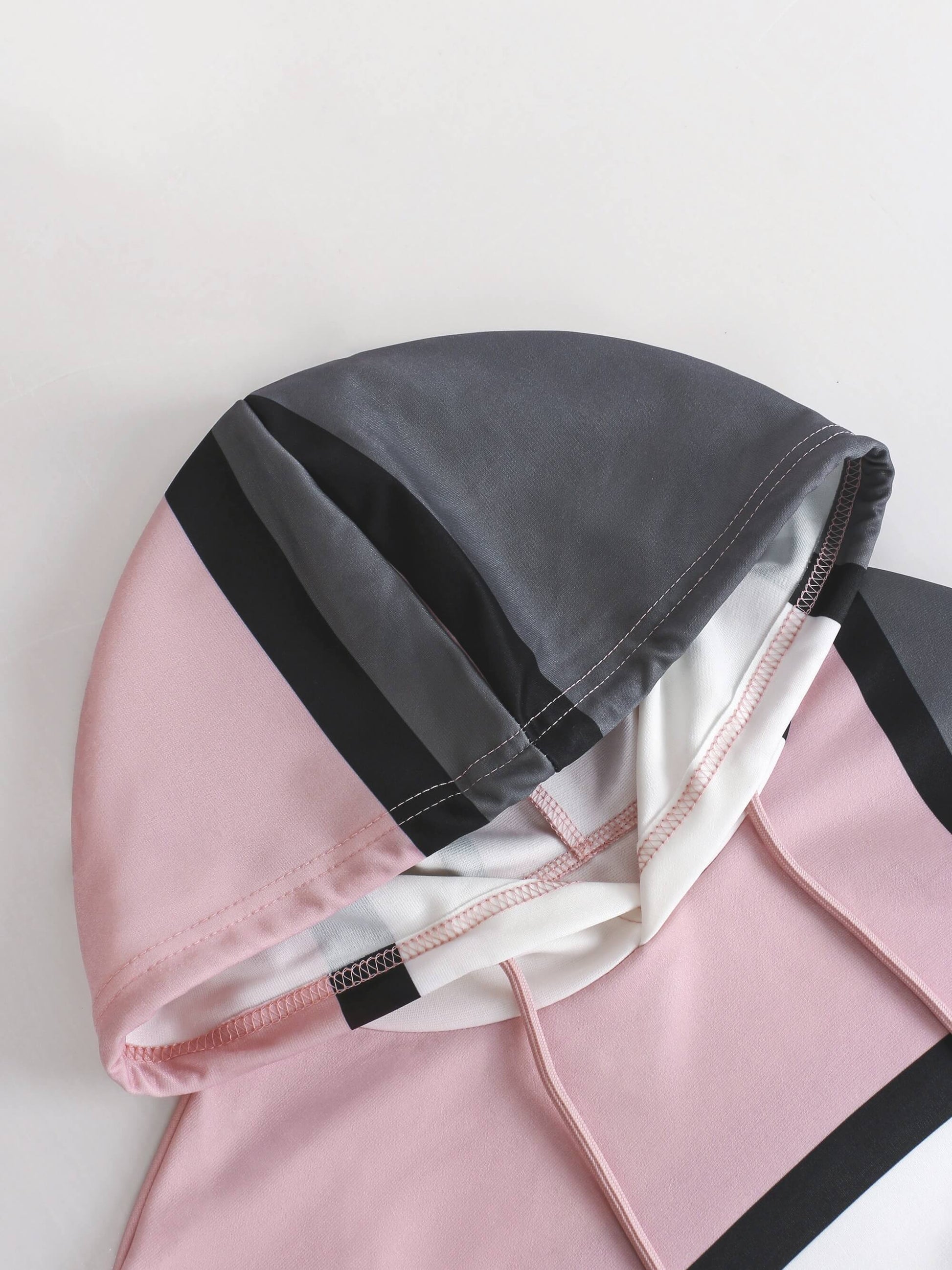 Pink and gray hooded garment on a light background