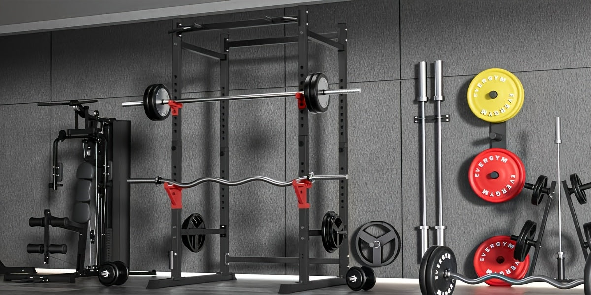 Gym equipment including a squat rack and weight plates on a gray wall.