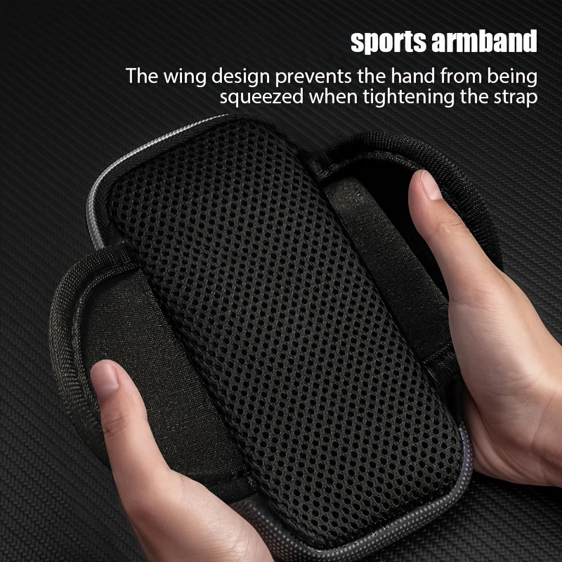 Black sports armband with wing design preventing hand squeezing, held by a hand on a dark background.