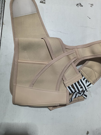 A beige posture corrector brace with adjustable straps, laid flat on a light gray surface.