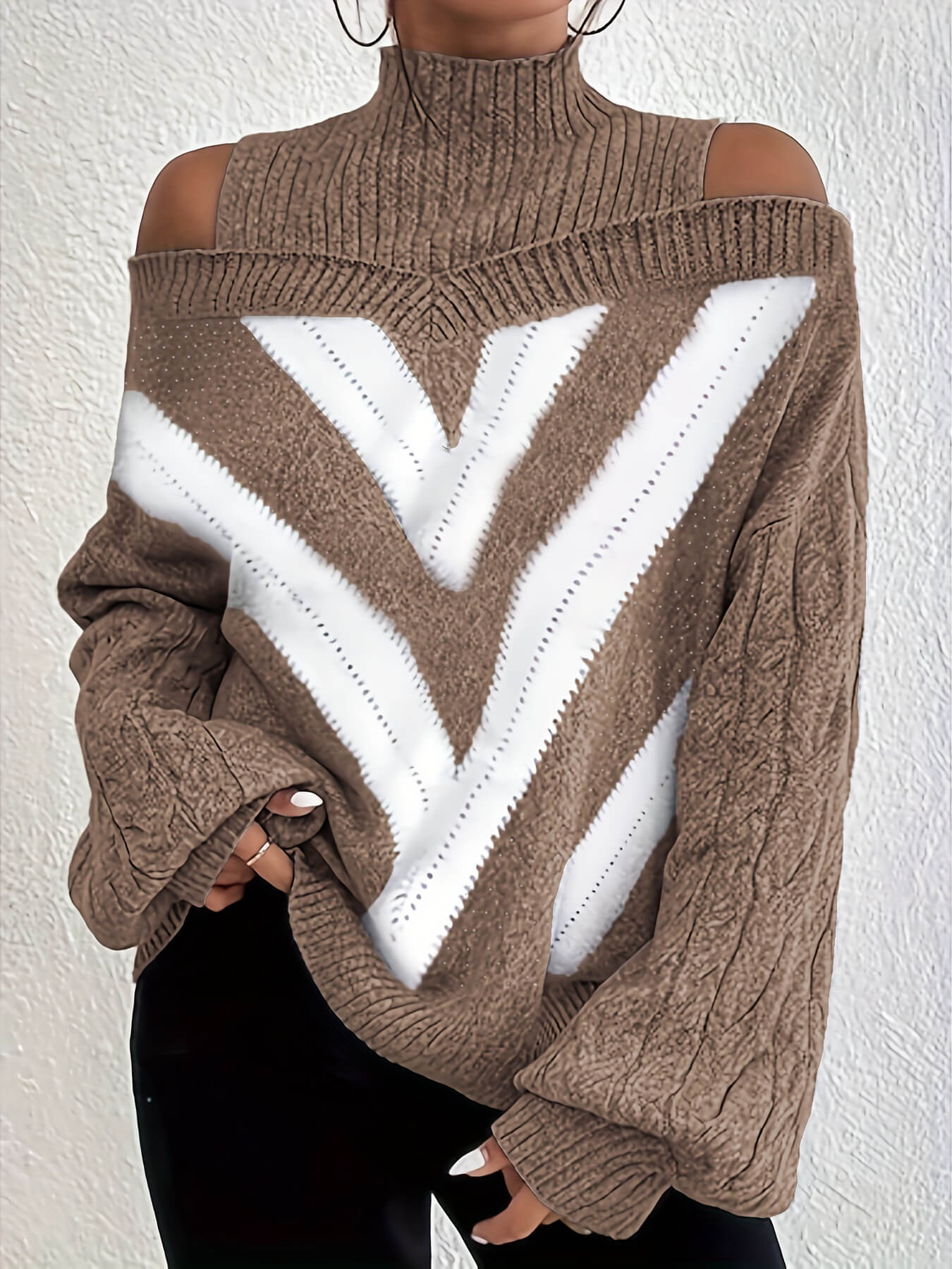 Brown and white off the shoulder sweater with cold shoulder design on a plain background