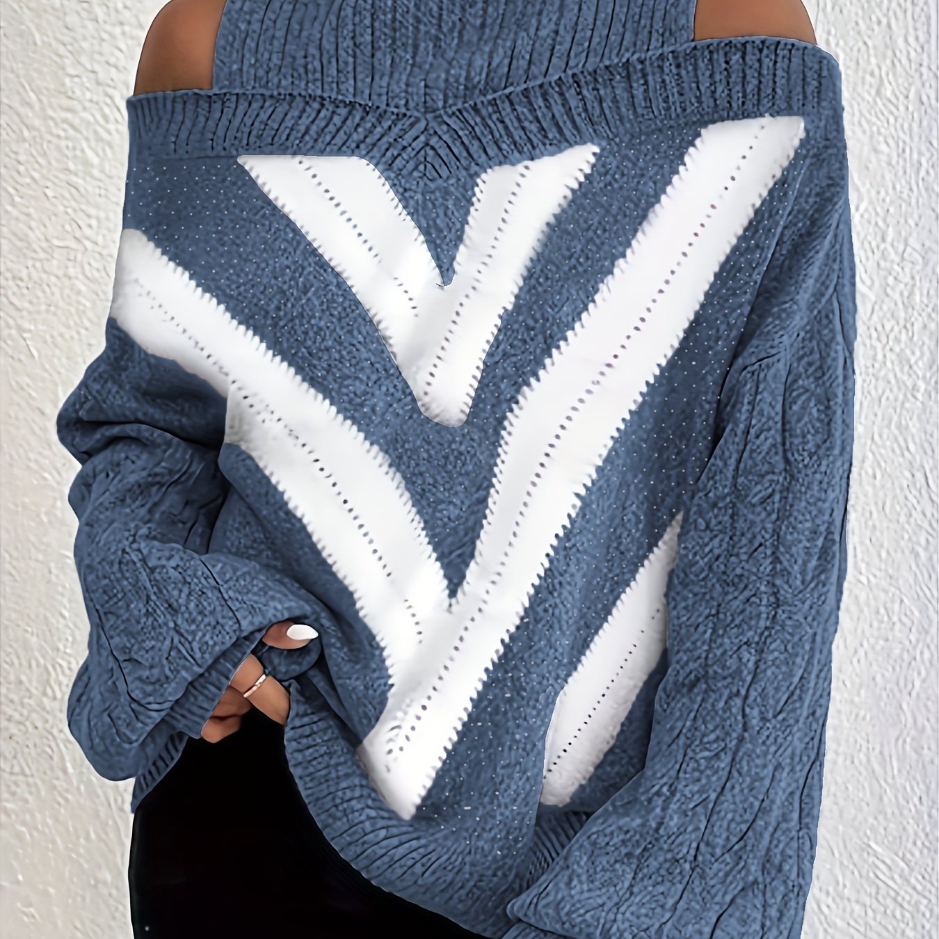 Blue off the shoulder sweater with a large white 'V' pattern on a plain background
