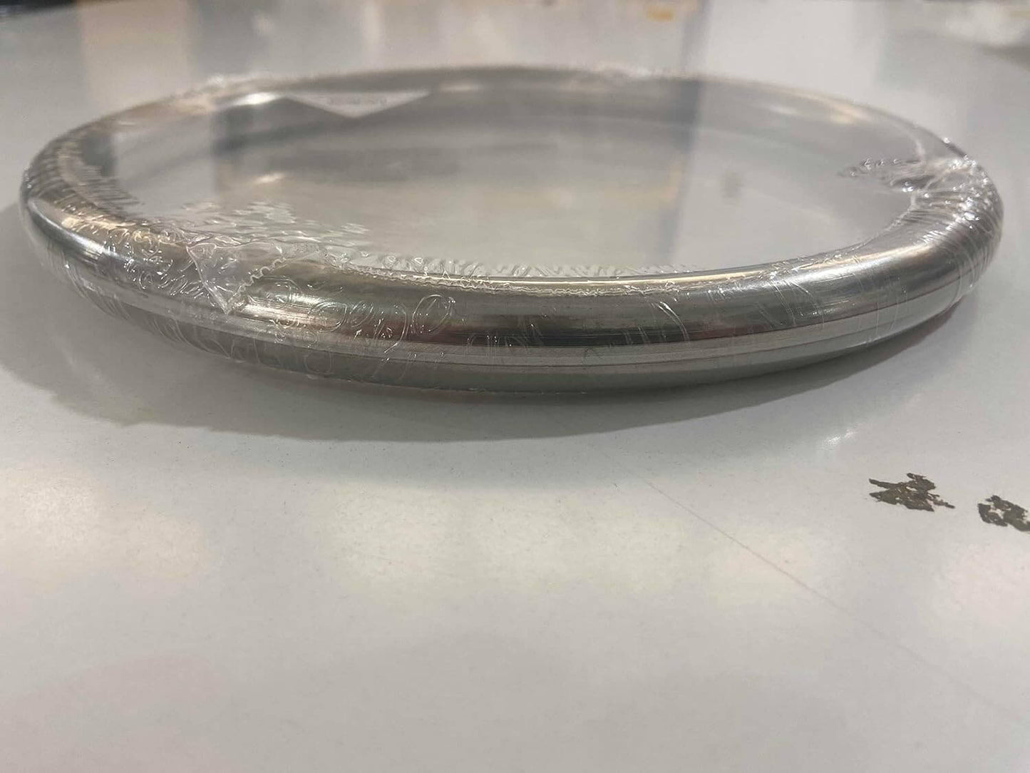 A silver wing chun ring on a white surface