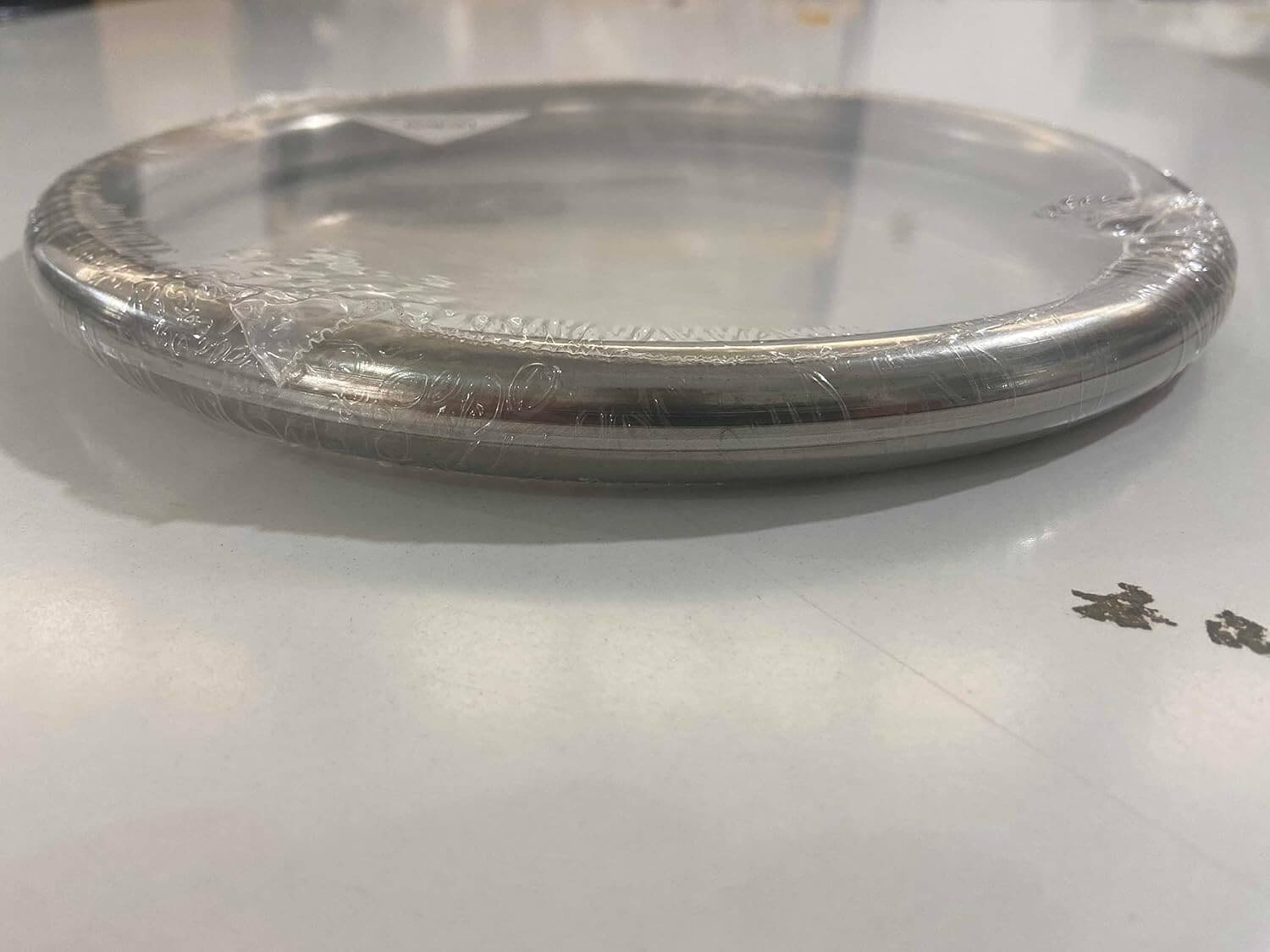 A silver wing chun ring on a white surface