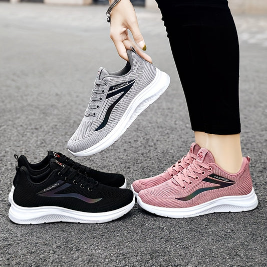 Three pairs of running shoes in black, gray, and pink on a road surface.