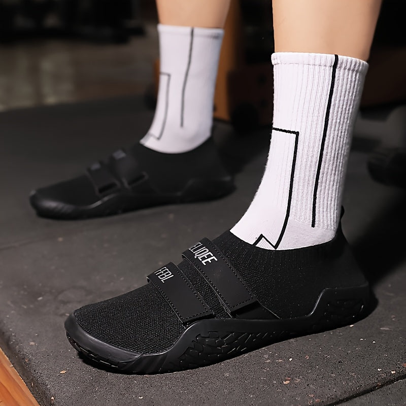 Black shoes for lifting weights with velcro straps on a white background