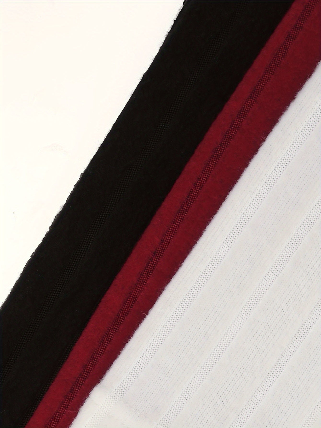 Close-up of fabric with black, red, and white stripes on a textured background