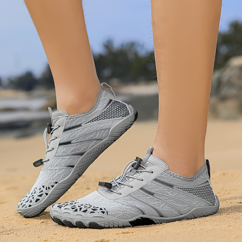 Gray deadlift shoes worn on a sandy surface with a blurred natural background