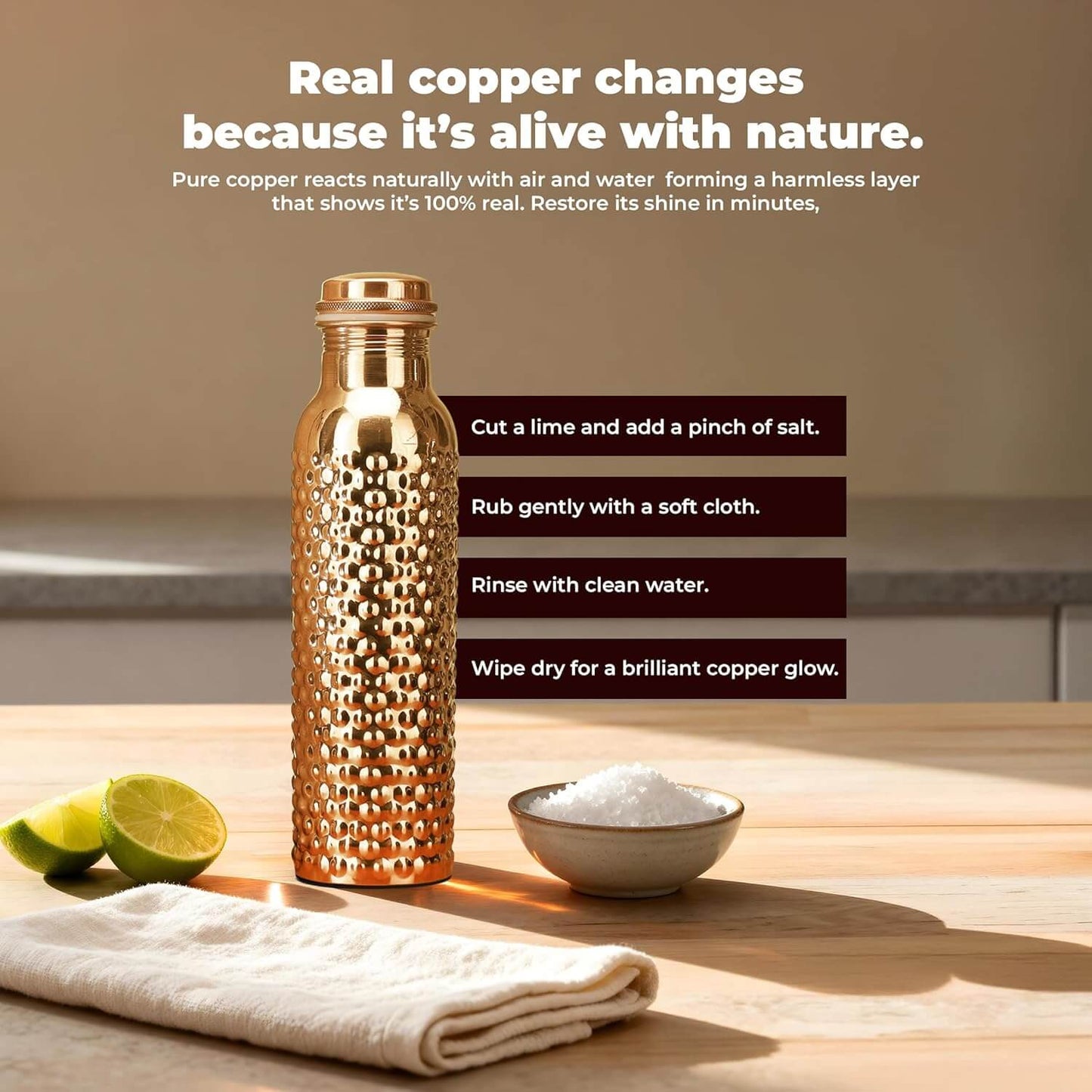 Copper water bottle on a wooden surface with lime, salt, and cloth, against a neutral background.