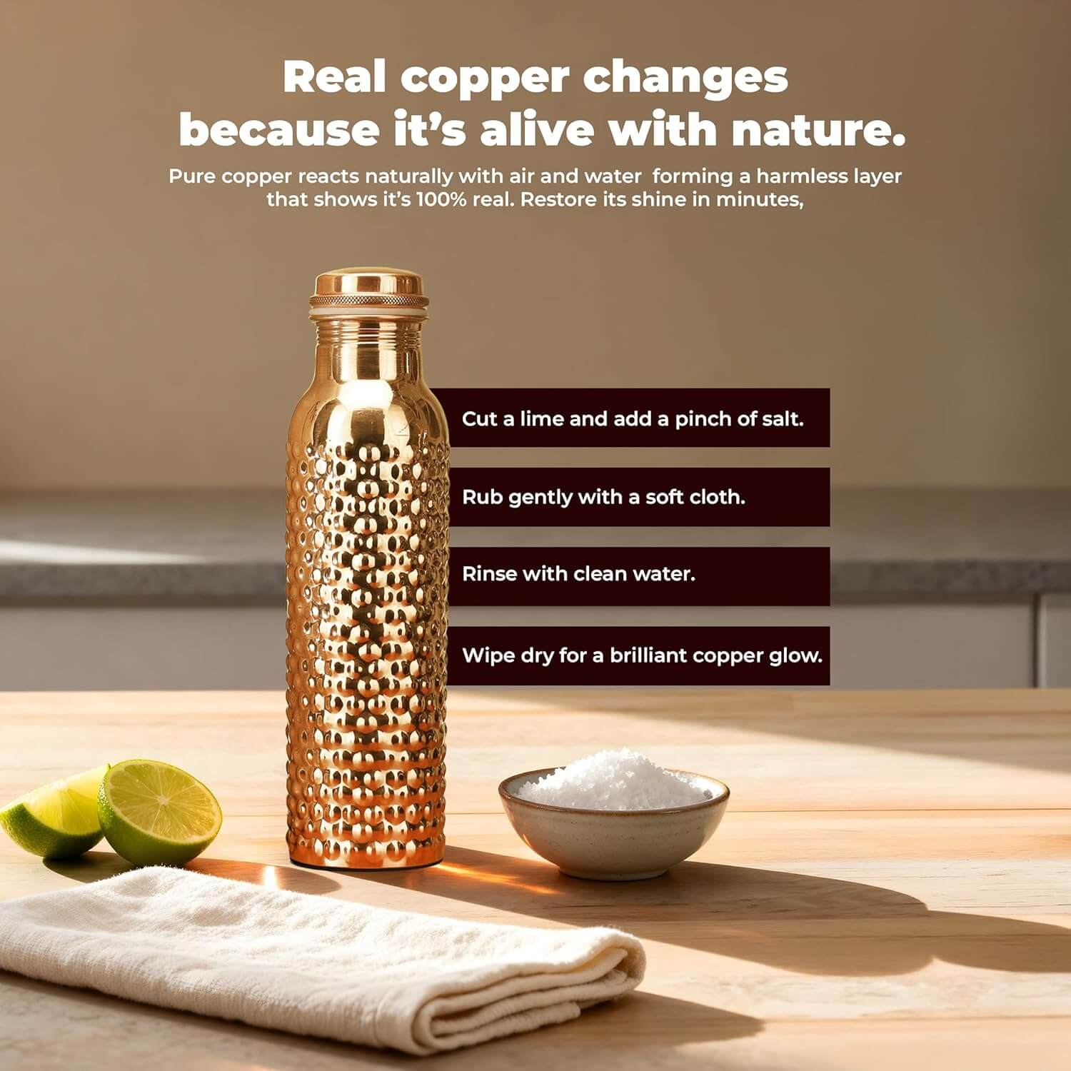 Copper water bottle on a wooden surface with lime, salt, and cloth, against a neutral background.