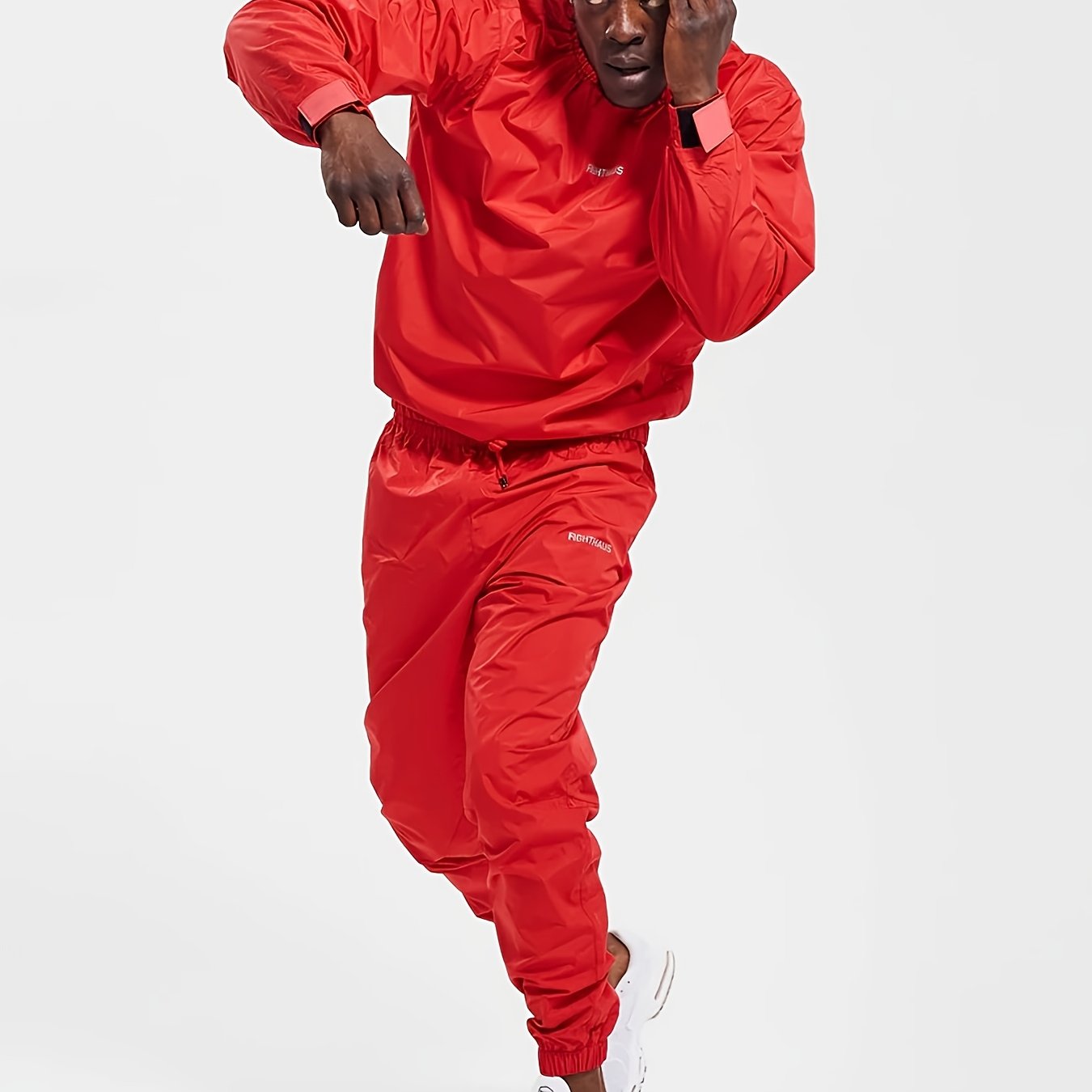 Person wearing a red mens sauna sweat suit on a white background