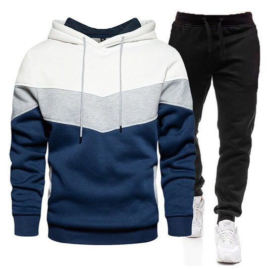 Color-blocked hoodie and black pants with white sneakers on a white background