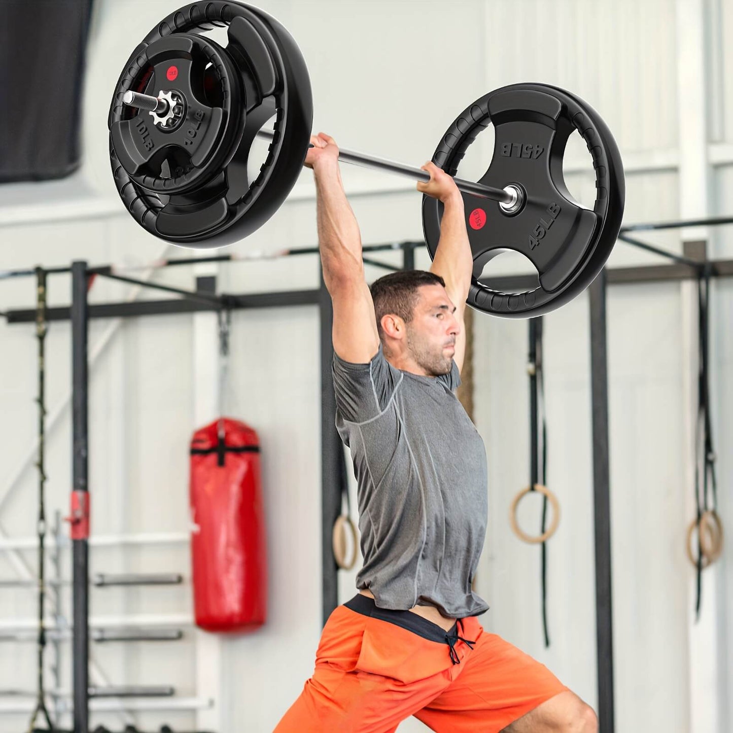 Man lifting a barbell with weight plates in a gym setting