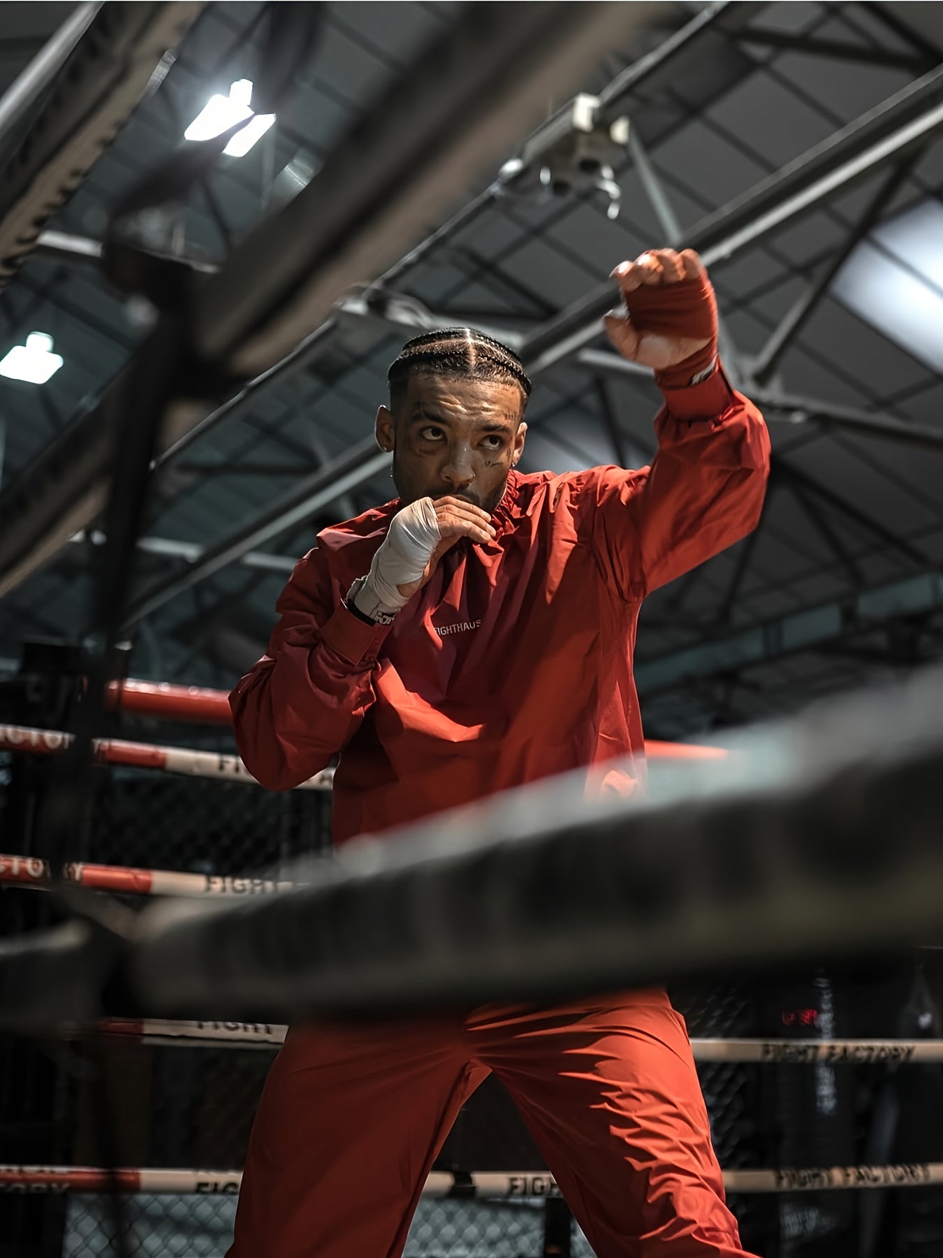 Boxer in red mens sauna sweat suit standing in a boxing ring
