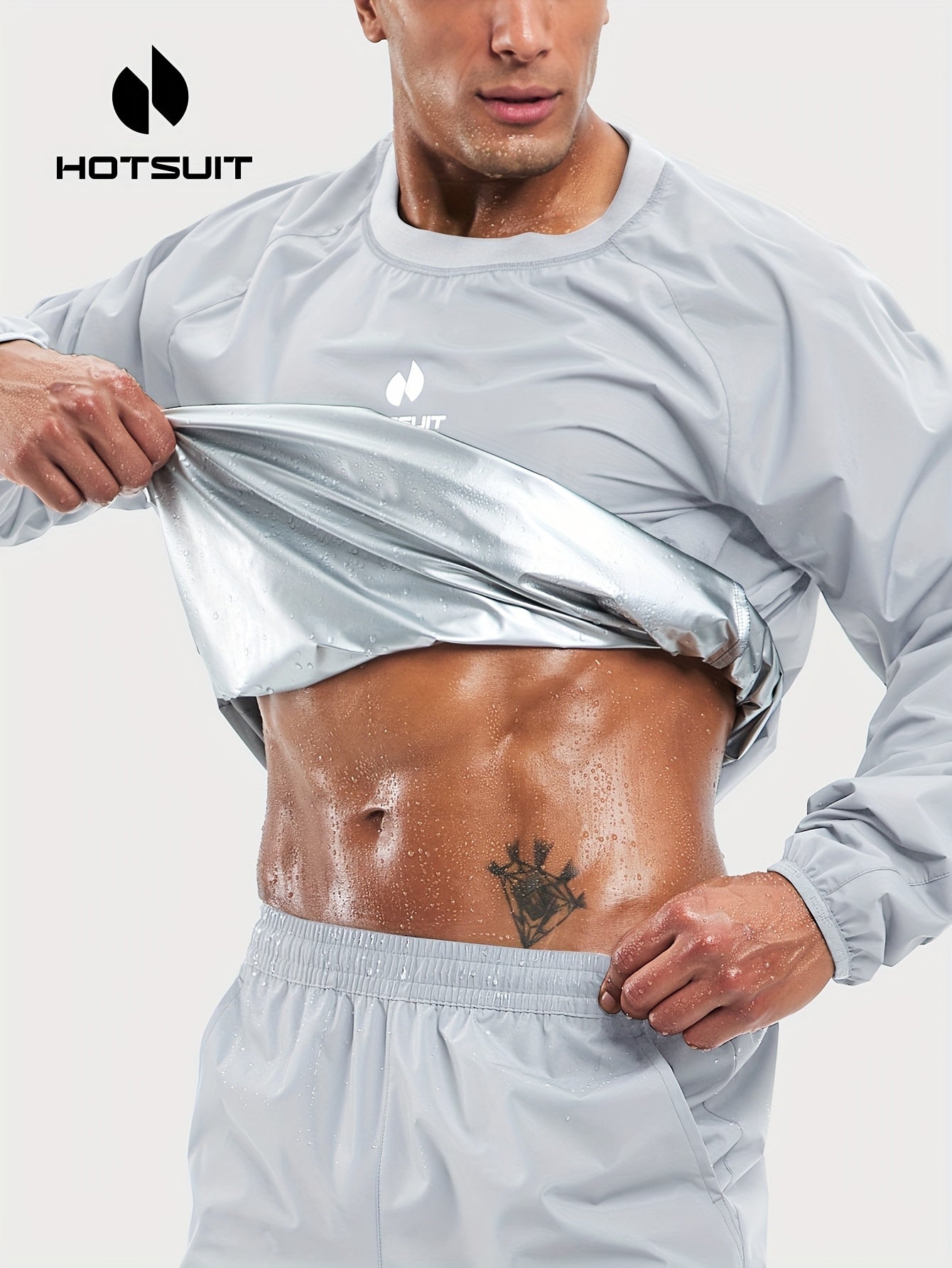 Man wearing a gray sauna sweat suit top athletic outfit with 'Hotsuit' branding, lifting his shirt to reveal a tattoo.
