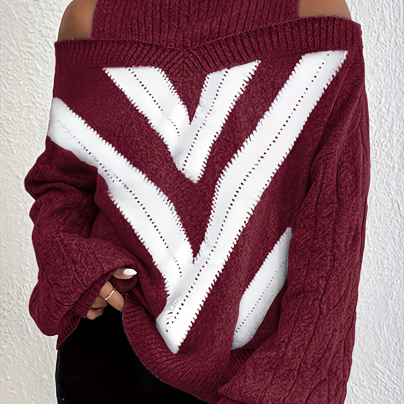 Maroon off the shoulder sweater with white V-shaped design on a plain background