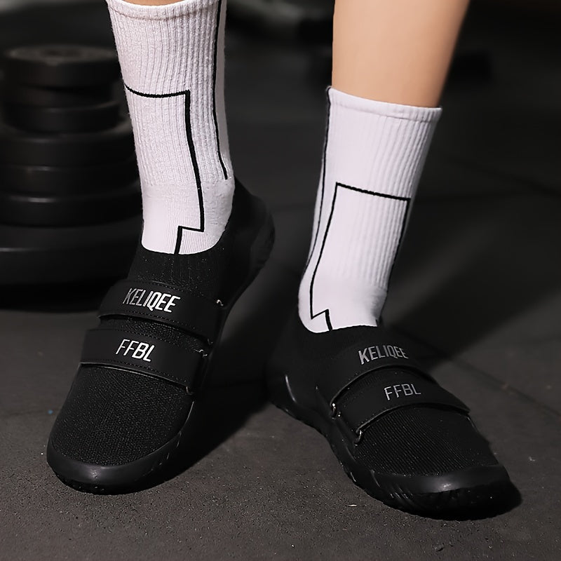 Black shoes for lifting weights with white socks featuring brand logos on a dark background