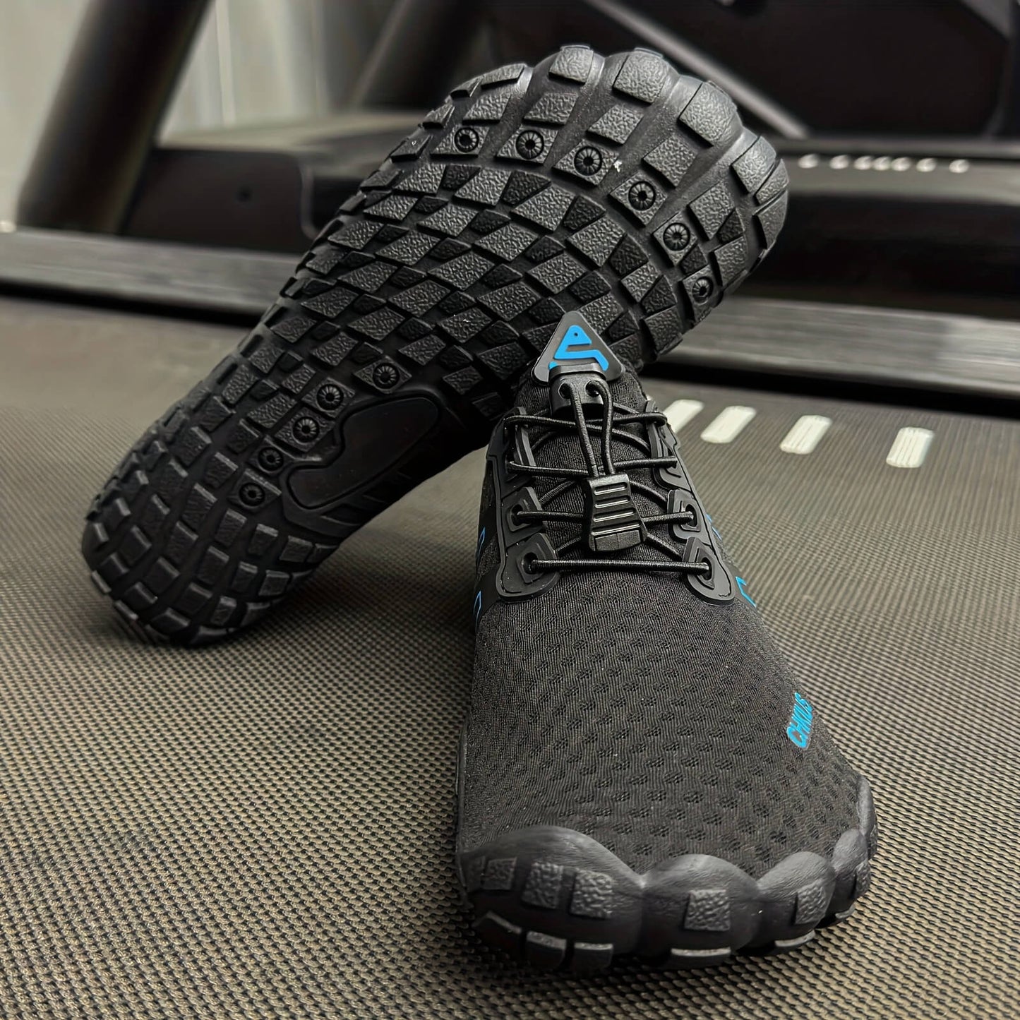 Black deadlift shoes with textured sole on a treadmill