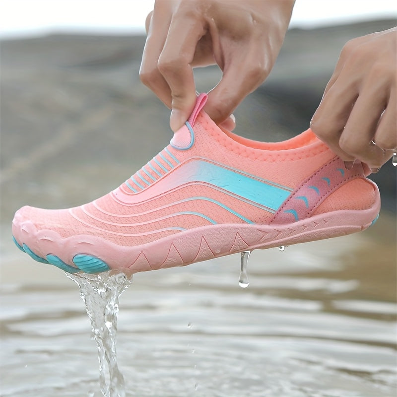 Pink and blue water hiking shoes being worn with water dripping from it, on a blurred natural background.