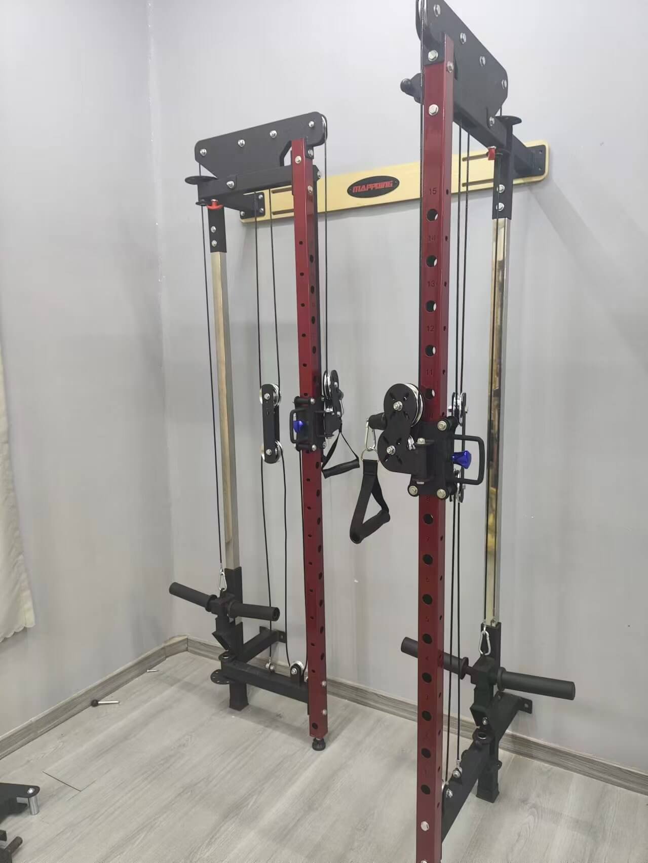 Home gym setup with a folding power cage against a white wall.